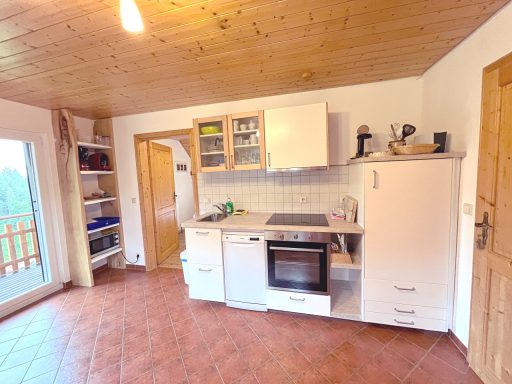 Eine helle Küche mit modernem Design, Kühlschrank, Herd und offenen Regalen.